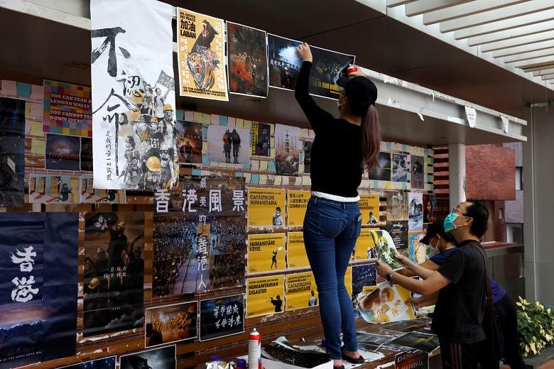 University of Hong Kong students putting up posters on campus yesterday to promote the upcoming pro-democracy protest and demand the release of 12 Hong Kongers under detention in Shenzhen. PHOTO: REUTERS