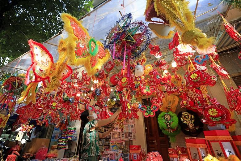 A woman in Hanoi, Vietnam, displaying lanterns and other decorations for sale for the upcoming Mid-Autumn Festival. The annual event is also known as "Children's Festival" in Vietnam because kids parade in the streets in the evening carrying lanterns