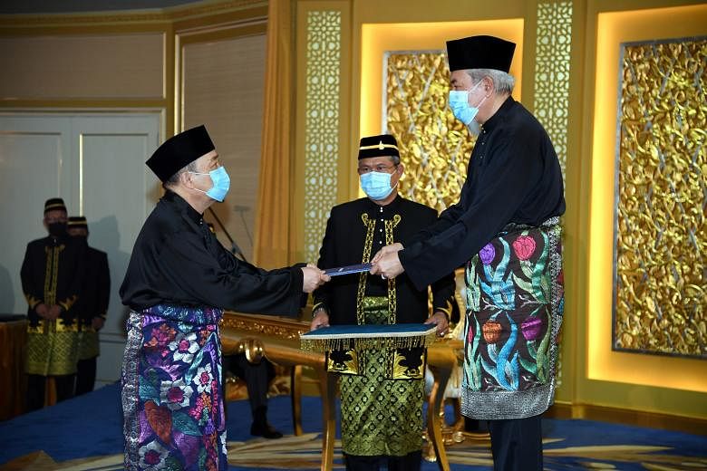 Datuk Seri Hajiji Mohd Noor (left) being sworn in by Sabah Governor Juhar Mahiruddin yesterday. Mr Hajiji's appointment notched up another big win for Malaysian Prime Minister Muhyiddin Yassin, who is facing a leadership challenge in Parliament from 