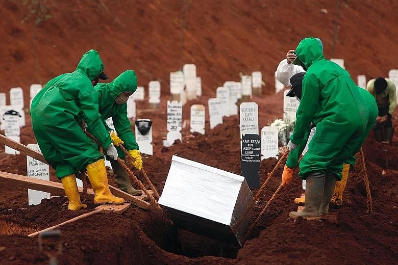 Workers burying the body of a Covid-19 victim yesterday at Pondok Ranggon Cemetery in East Jakarta. Capacity at the cemetery was expected to be at a critical state this month. Since March, 6,248 bodies have been buried in accordance with Covid-19 pro