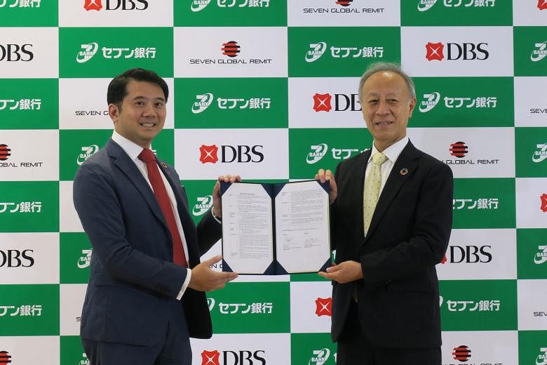 Seven Bank president Yasuaki Funatake (right) and DBS Japan country head Ken Foo with the memorandum of understanding on the deal. ST PHOTO: WALTER SIM
