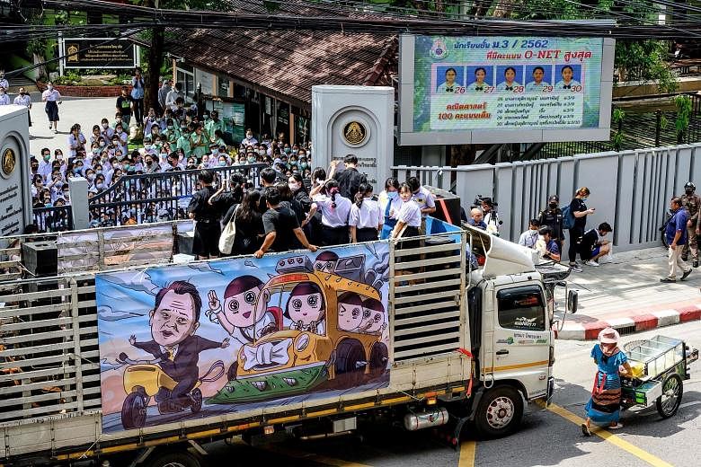 A student leader speaking from a truck during a protest in front of a school in Bangkok yesterday. The banner on the truck shows Thailand's Education Minister Nataphol Teepsuwan being chased by protesting schoolchildren. PHOTO: AGENCE FRANCE-PRESSE