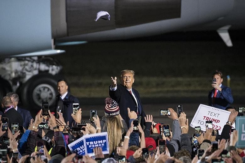 United States President Donald Trump tossing a cap to supporters at a rally in Duluth, Minnesota, on Wednesday. Alarm bells were raised after a close aide, Ms Hope Hicks, received a positive Covid-19 diagnosis during the campaigning trip. Chinese obs