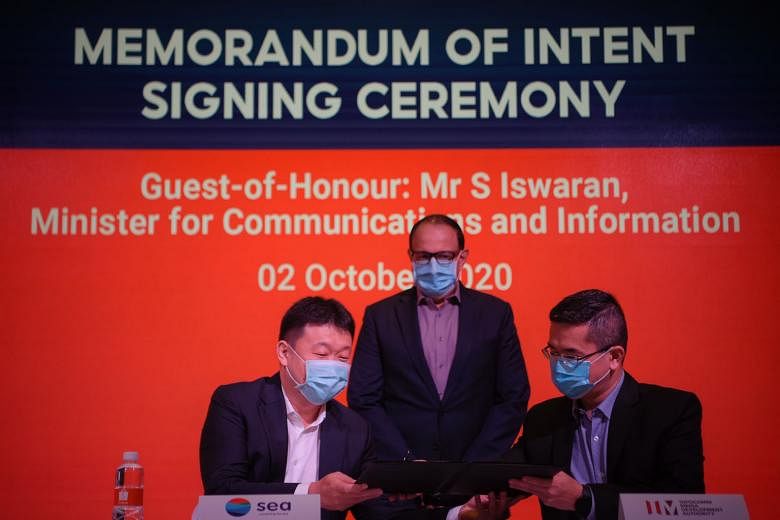 Minister for Communications and Information S. Iswaran witnessing the signing yesterday of the memorandum of intent between Sea and the Infocomm Media Development Authority (IMDA), by Sea chairman and group chief executive Forrest Li (left) and IMDA 