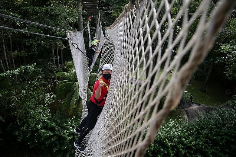 Senior Minister of State for Defence and Safra president Zaqy Mohamad (in red) on a canopy walk at the Adventure Sports Centre at Safra Yishun yesterday. He was joined by Safra member Muhammed Sabri Mahmod and his 17-year-old daughter Nurdiana. The n