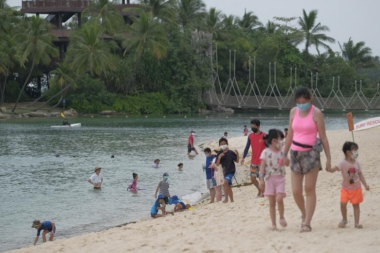 People yesterday at Palawan Beach, where visitors were issued with wristbands upon admission. A Sentosa Development Corporation spokesman said wristbands have been progressively introduced to familiarise Sentosa's beachgoers with the upcoming booking