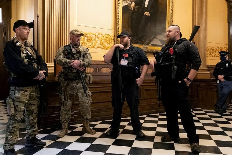 Armed members of a militia group, who are among those charged in Michigan over terrorism-related acts, in the Lansing state capitol in April.