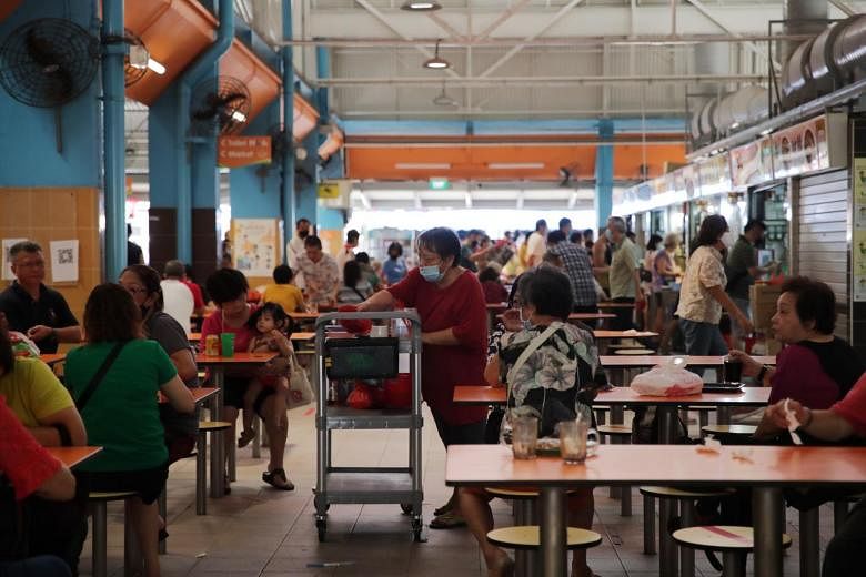 A cleaner clearing used plates and cutlery at Teck Ghee market on Aug 10, 2010.
