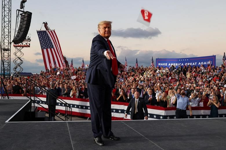 US President Donald Trump tossing out face masks to the crowd at a campaign rally, his first since he announced his Covid-19 diagnosis, at an airport in Sanford, Florida, on Monday. The event is the first of six planned for this week. He is also expected 