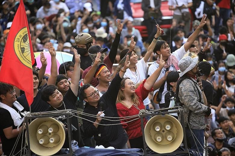 Thai human rights lawyer Anon Nampa (centre) and other activists flashing the three-finger anti-dictatorship salute from a truck during an anti-government protest in Bangkok yesterday. PHOTO: EPA-EFE
