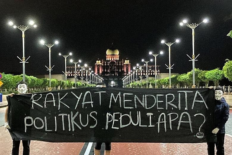 Photos of people holding up a banner at various sites in Malaysia's administrative centre, Putrajaya, were posted by non-governmental organisation Gerak Malaysia on Twitter on Tuesday. The banner reads: "People are suffering. Do politicians even care