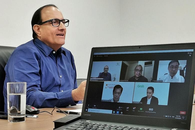 Communications and Information Minister S. Iswaran yesterday interacting with the other panellists at the virtual dialogue (on monitor screen, clockwise after Mr Iswaran): Associate Professor Kenneth Paul Tan of NUS' Lee Kuan Yew School of Public Pol