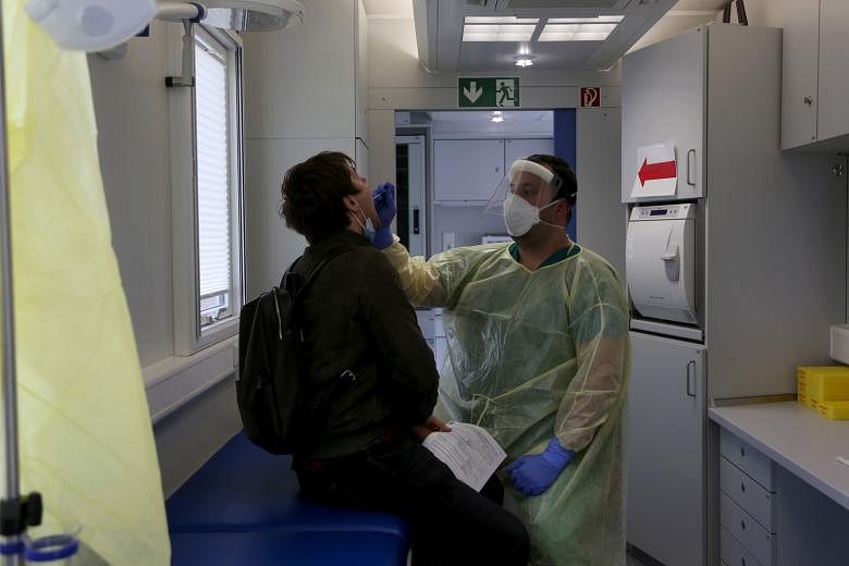 A health worker administering a Covid-19 swab test on a traveller in Berlin on Monday. Germany, where infections jumped by 4,122 on Tuesday to 329,453 in total, has secured nine million so-called antigen tests per month that can deliver a result in m