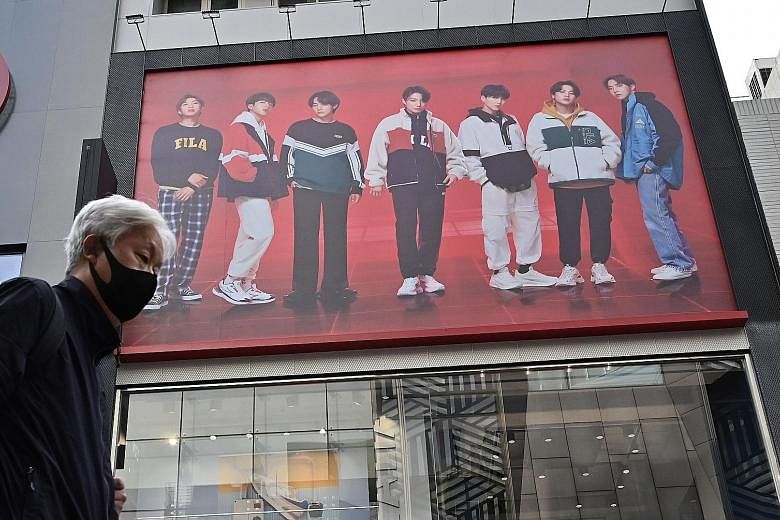 A commercial showing K-pop group BTS (above) in a shopping district in Seoul. The share prices of Big Hit Entertainment, the company behind the group, more than doubled in the South Korean stock market in its IPO yesterday.
