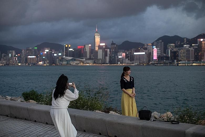 Women snapping photos at the West Kowloon Waterfront Promenade in Hong Kong last week. Transport Minister Ong Ye Kung yesterday called the move to set up an air travel bubble between Singapore and Hong Kong a small but significant step for the two av
