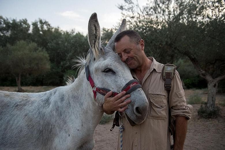 Mr Luis Bejarano (left), president of The Happy Little Donkey association in Andalusia, hugging a donkey at the Enchanted Forest in Hinojos, south of Spain. He started the Doctor Donkey therapy to ease the stress of healthcare workers who have been d