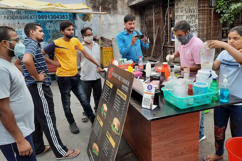 Mr Ravi Kant at his food stall in Noida, which sells mostly burgers, sandwiches and beverages. He saw a surge in customers after a news agency tweeted about him and his stall. ST PHOTO: DEBARSHI DASGUPTA