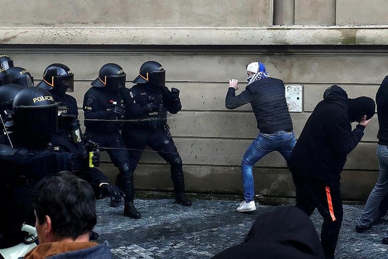 A riot police officer in a face-off with a protester during a rally in Prague on Sunday against social distancing rules and government measures to stem the spread of Covid-19. The Czech Republic faces Europe's worst spread of the disease.