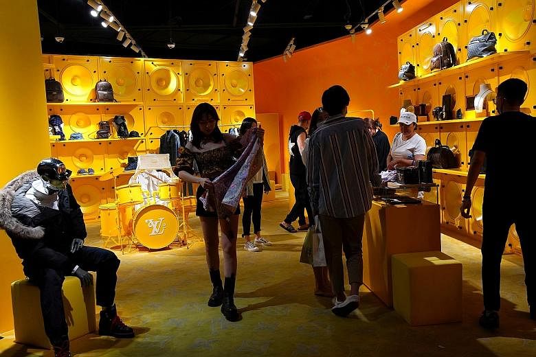 Customers at a store of French luxury brand Louis Vuitton in a shopping mall in Beijing. Both retail sales and industrial production gained momentum in China last month, reassuring markets that the country's recovery is on track.