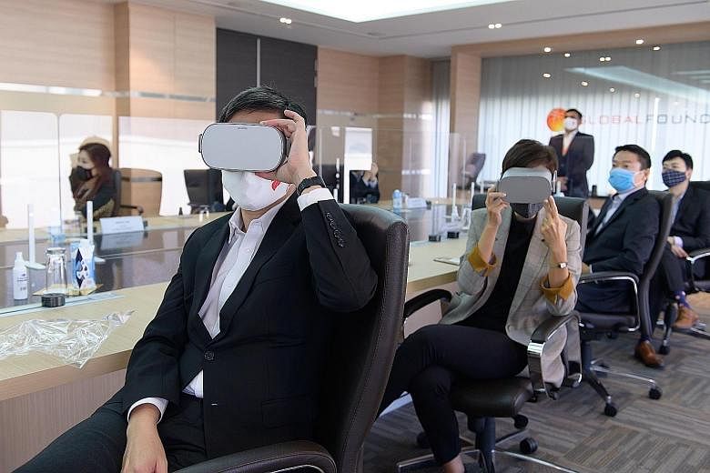 Minister for Trade and Industry Chan Chun Sing and Minister for Manpower Josephine Teo donning headsets to experience a virtual reality tour of the GlobalFoundries Singapore facility during their visit to the semiconductor firm yesterday. PHOTO: MINI