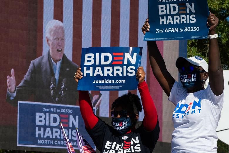 Supporters of Democratic challenger Joe Biden cheering during his campaign stop in Durham, North Carolina, on Sunday. Mr Biden is running 10.5 points ahead of Mr Trump nationally, says the FiveThirtyEight website which tracks poll data. A voter depos