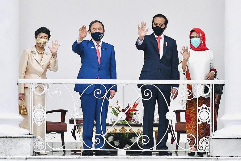 Japanese Prime Minister Yoshihide Suga and his wife Mariko with Indonesian President Joko Widodo and his wife Iriana at the Presidential Palace in Bogor yesterday. Mr Suga, who is the first foreign leader to visit Indonesia since the Covid-19 pandemi