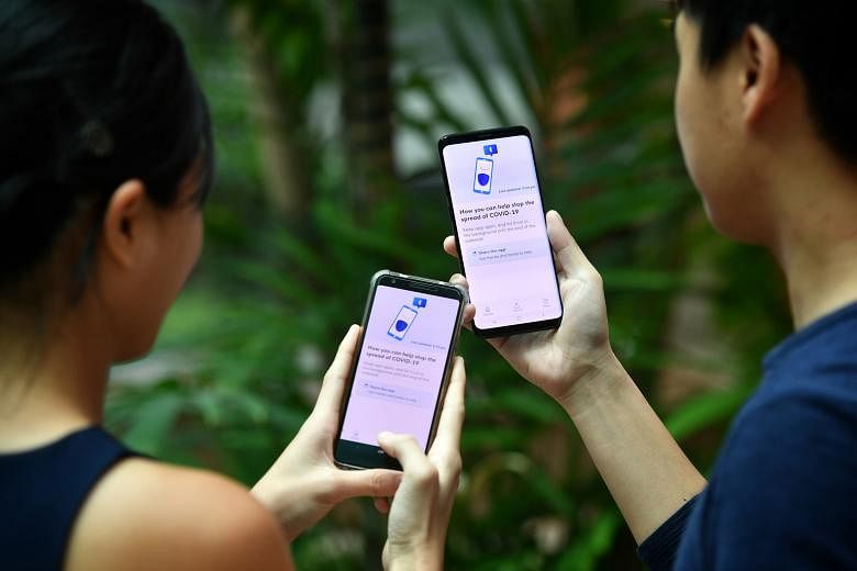 Checking in with the TraceTogether token (left) or app will be mandatory at venues including workplaces and malls, as Singapore prepares for phase three of its reopening.