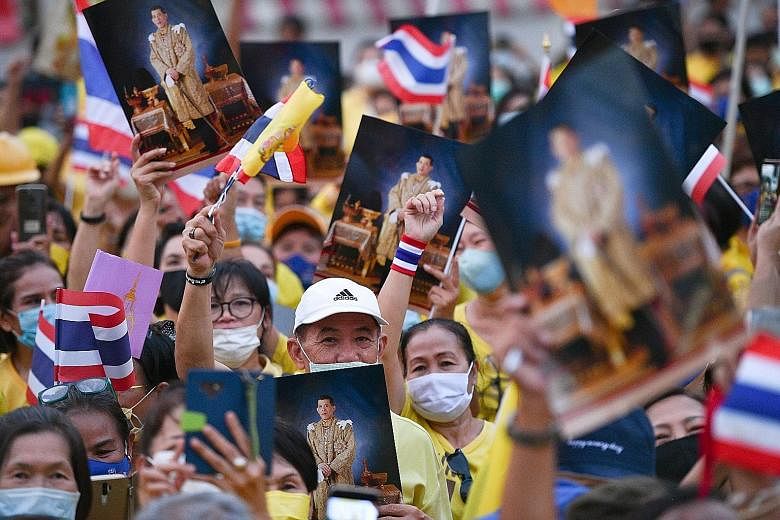 Above and right: Supporters of the monarchy at a rally opposing the student-led pro-democracy movement in Bangkok yesterday. Such rallies in support of King Maha Vajiralongkorn have raised fears of clashes between the rival groups. The emergency decr