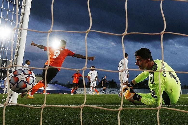 Real Madrid goalkeeper Thibaut Courtois watching forlornly as teammate Raphael Varane scores an own goal in the 3-2 loss to a depleted Shakhtar Donetsk in the Champions League. It was the Ukrainian side's first win over Real. PHOTO: REUTERS