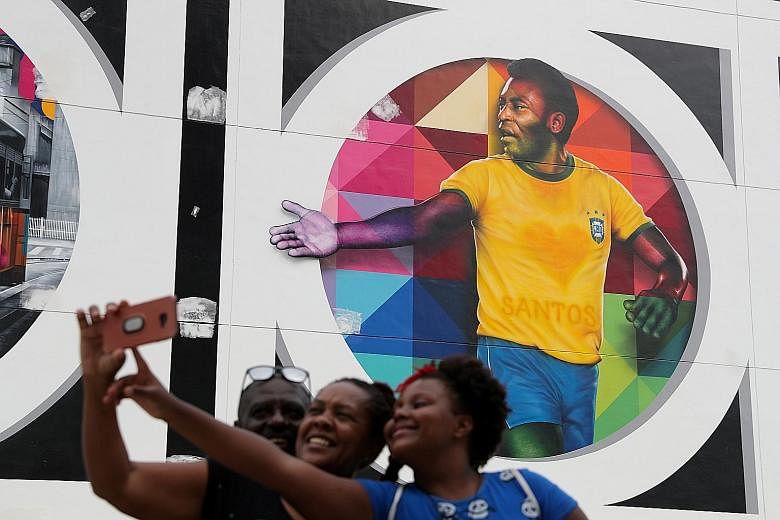 Fans taking a wefie in front of a mural depicting Brazilian legend Pele in Santos on Tuesday. The footballer turns 80 today. PHOTO: REUTERS