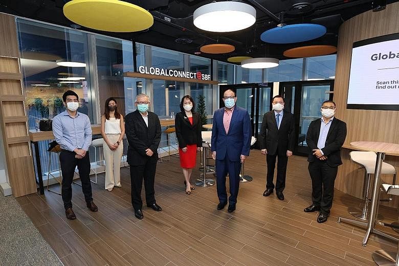 Minister for Communications and Information S. Iswaran (in blue suit) with Singapore Business Federation (SBF) office-bearers (from far left), Mr Collin Sim, assistant market development manager of Tee Yih Jia Food Manufacturing; Ms Priscilla Ng, mar