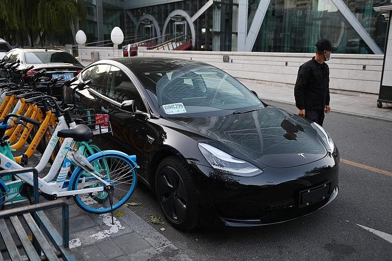 Above: The Tesla Model 3. The electric carmaker said profits in the past quarter more than doubled. Left: Funan, one of the malls owned by CapitaLand Mall Trust. The trust saw its gross revenue tumble 25.3 per cent to $150.3 million.