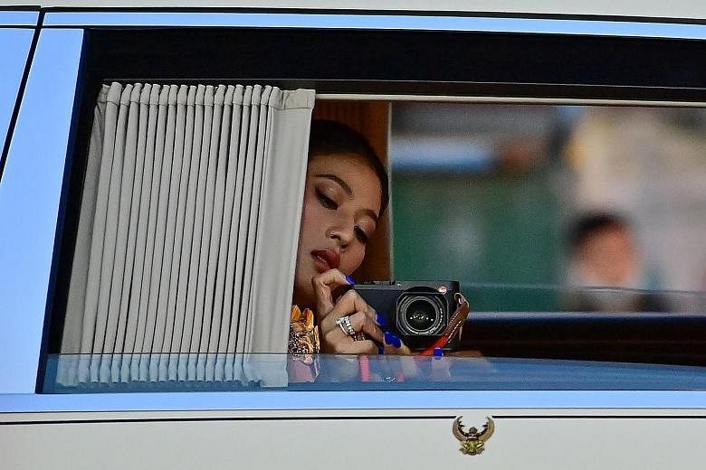 Princess Sirivannavari Nariratana taking a picture of royalist supporters on the way to the Grand Palace with her family for the Buddhist ceremony yesterday.