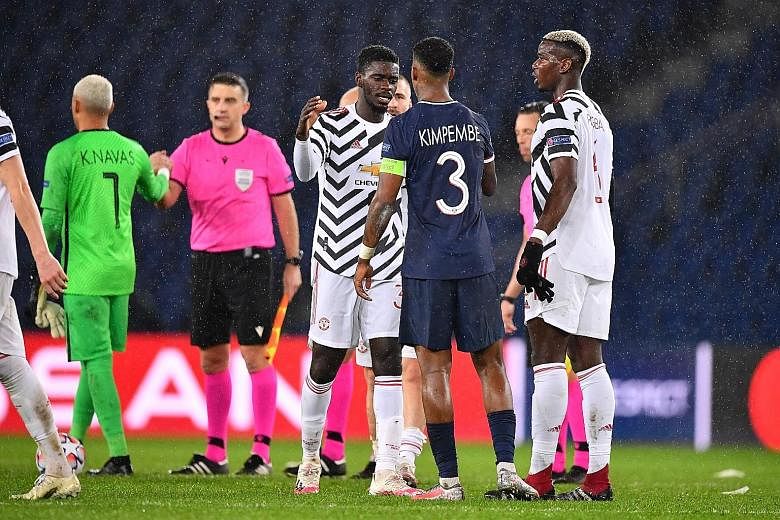 Manchester United's Axel Tuanzebe shaking hands with Paris Saint-Germain defender Presnel Kimpembe during their Champions League match on Tuesday. Tuanzebe could keep his place when United face Chelsea today.
