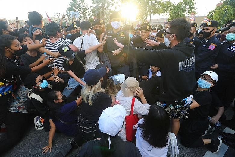 Police scuffling with anti-government demonstrators near a royal motorcade carrying Thailand's Queen Suthida and Prince Dipangkorn, in front of Government House on Oct 14, the 47th anniversary of the 1973 student uprising, in Bangkok.