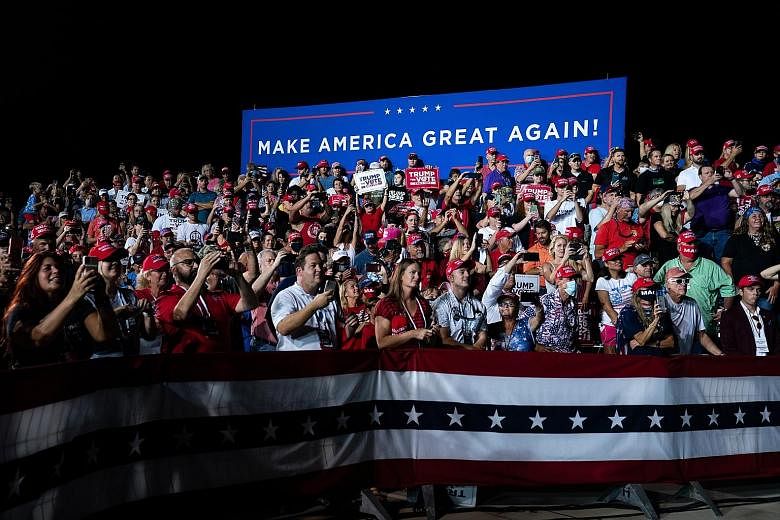 A campaign event on Friday in Florida (above) was among the rallies US President Donald Trump has held with increasing frequency, while events for rival Joe Biden have been more socially distanced, like this one on Friday in Michigan (left).