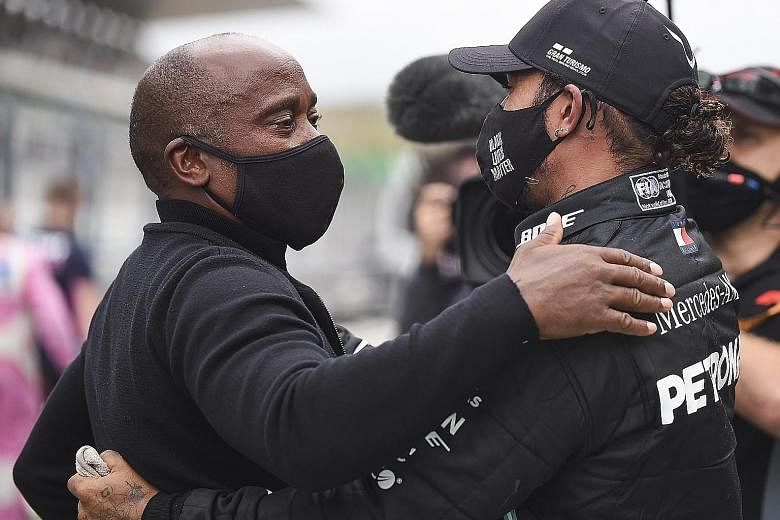 Six-time Formula One champion Lewis Hamilton and his father, the man behind his success, hug after he won the first Portuguese Grand Prix in 24 years yesterday at the Algarve circuit. PHOTO: EPA-EFE
