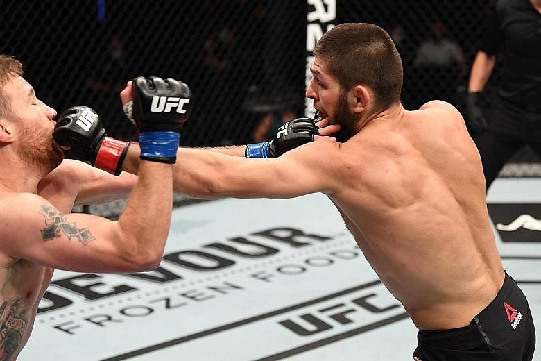 Russian Khabib Nurmagomedov punching Justin Gaethje in their lightweight title bout at UFC 254 in Abu Dhabi on Saturday. The American submitted barely two minutes into the second round. PHOTO: UFC