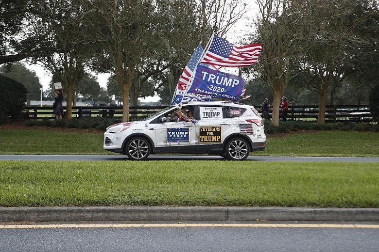 Above: A motorist on the move to show his support for President Donald Trump during his campaign stop at The Villages Polo Club in The Villages, Florida, last Friday. Below: