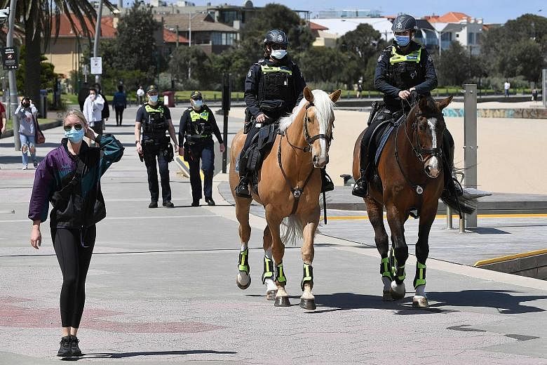 A police patrol in Melbourne's St Kilda Esplanade yesterday. Stay-at-home orders for Melbourne residents will be lifted from midnight today. Restaurants, beauty salons and retail stores will also be permitted to reopen. The move comes after the city 