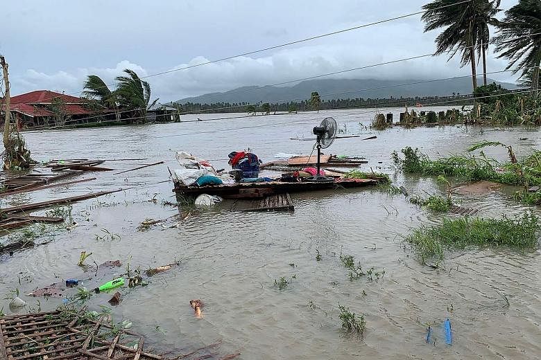 Above: The devastation left by Typhoon Molave in Pola, Oriental Mindoro province, yesterday. Left: Residents of the town heading back to their homes yesterday.
