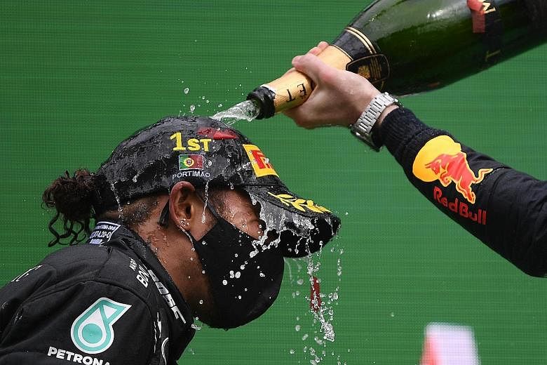 Mercedes' Lewis Hamilton celebrating with champagne on the podium after winning the Portuguese Grand Prix last weekend for a record 92nd victory in Formula One.