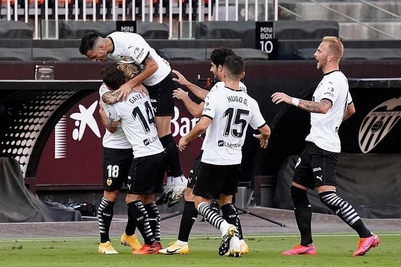 Valencia players celebrating Daniel Wass' goal in their 1-1 draw with Huesca last month. It is the team's only draw this season, with Valencia winning two and losing four of their other La Liga matches.