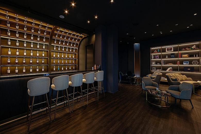 The Macallan Experience at Raffles Hotel Singapore features a tunnel lined with oak casks (above) and a bar and lounge (left) where guests can sample a variety of drams from the distillery.