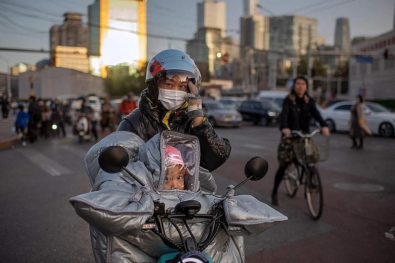 A woman and her daughter wearing protective gear as a preventive measure against the coronavirus in Beijing last Wednesday. While life feels normal again in much of the country amid China's efforts in containing the outbreak, concerns remain about an