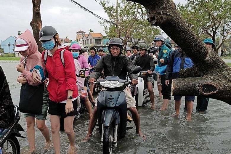 Local residents coping with the floods in the aftermath of Typhoon Molave in Hoi An, Quang Nam province, Vietnam, yesterday. Molave made landfall in Quang Ngai province, to the south of Hoi An.