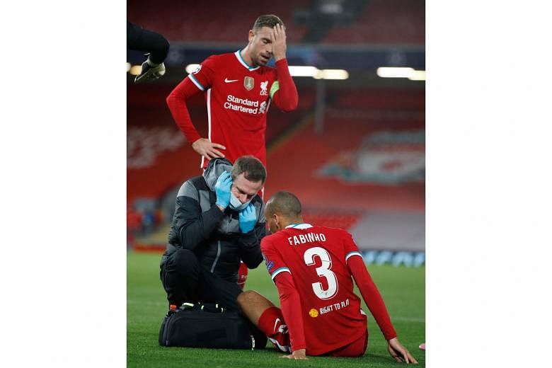 Left: Liverpool midfielder Fabinho receiving treatment after an injury in the 2-0 Champions League win over Midtjylland on Tuesday, as captain Jordan Henderson holds his head in concern. Below: Rhys Williams, the 19-year-old Liverpool centre-back, vy