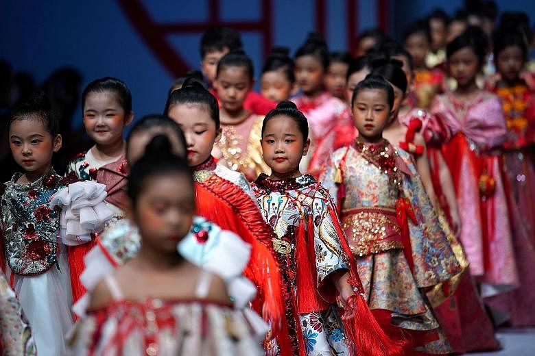 FASHION FANS:Models presenting creations from SGM Art Mouse Ji during China Fashion Week in Beijing last Sunday. The fashion event runs from Oct 24 to this Sunday. KIDS AT WORK: Children are also roped in as models, such as for this Mibai Spring/Summ