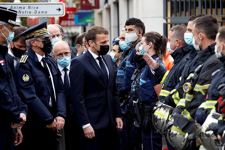 French President Emmanuel Macron visiting the site of the attack yesterday. He vowed that "France will not give up on our values" as he urged people of all religions to unite and not "give in to the spirit of division". PHOTO: REUTERS French security
