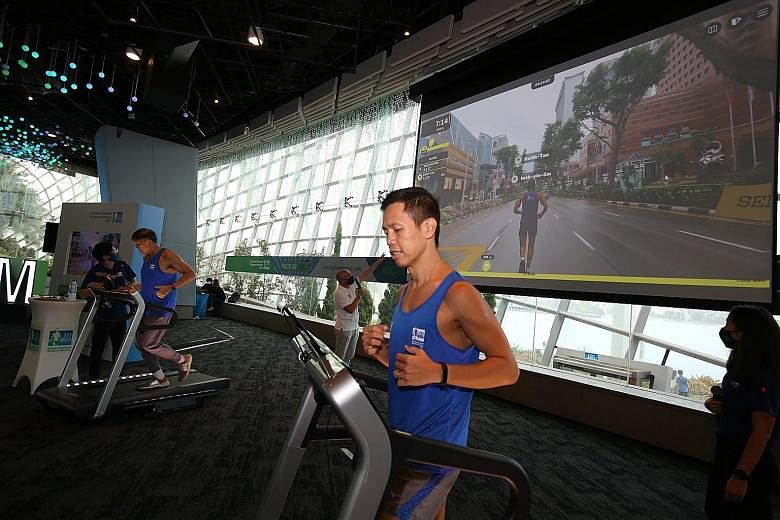 Keith Tan (right) and Lim Teck Yin, chiefs of the Singapore Tourism Board and Sport Singapore respectively, trying the augmented reality run on treadmills yesterday. The treadmills were affixed with tablets tracking runners' avatars on a virtual run 